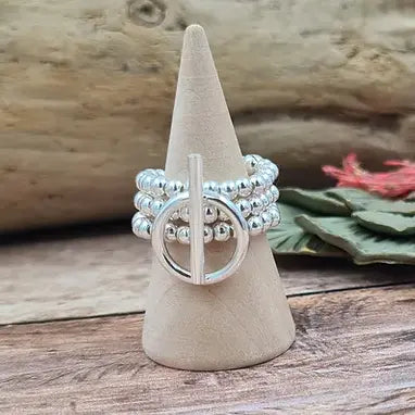 Bague en argent créée par MEG Creation sur un cône en bois